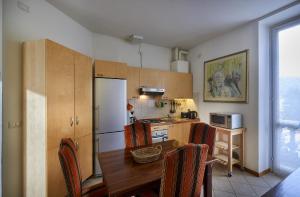 a kitchen with a wooden table and a kitchen with a refrigerator at Varenna Perfect Place 2 Suites in Varenna