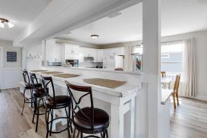 a kitchen with a large counter with stools around it at Malibu Beach House in Dauphin Island