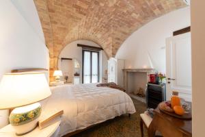 una camera con un grande letto e un muro di mattoni di Dimora Morello a Poggio Morello
