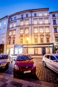 a red car parked in front of a building at Ahoy! Hostel in Prague
