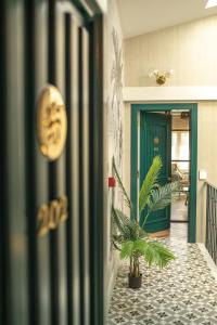 a hallway with a green door and a potted plant at Apartamentos Boutique Fuente Real in Comillas