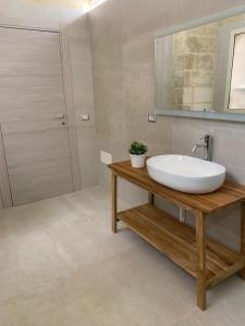 un bagno con un lavandino bianco e uno specchio di CASA LOCA Intera casa a due passi da Porta San Biagio a Lecce