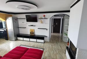 salon z czerwoną kanapą i telewizorem w obiekcie Apartament Mara w mieście Jurilovca