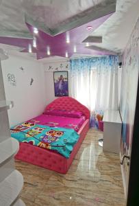 ein Schlafzimmer mit einem roten Bett in einem Zimmer mit lila Decken in der Unterkunft Apartament Mara in Jurilovca