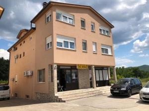 a building with two cars parked in front of it at Pansion Modana Medjugorje in Međugorje