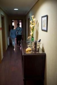 埃爾謝戈的住宿－埃西耶格別墅酒店，一位女士在走廊上走下,在走廊上摆着鲜花