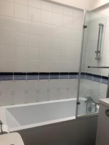 a bathroom with a bath tub and a toilet at Le nid normand in Honfleur