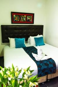 um quarto com uma cama grande e almofadas azuis em Central House Hotel em Bogotá