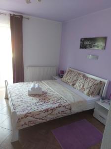 una camera da letto con un letto con copriletto bianco di Guest House Mačić a Korenica