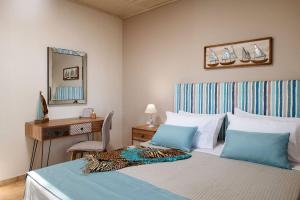 een slaapkamer met een bed, een bureau en een spiegel bij Villa Venia in Tragaki
