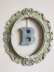 a silver picture frame with a letter b in it at Ferienwohnung B im Ferienhaus Antika in Ratzeburg