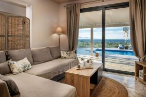 sala de estar con sofá y vistas a la piscina en Villa Venia, en Tragaki