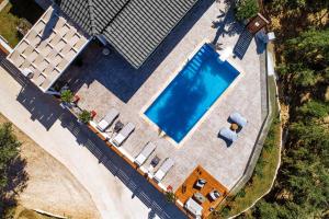 an overhead view of a swimming pool with loungers and a house at Villa Venia in Tragaki