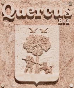 un cartello con un albero e due persone e uccelli di Quercus ad Alberobello
