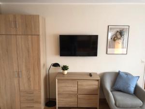 a living room with a couch and a tv on a wall at BUDE'55 Loft 14 in Winterberg