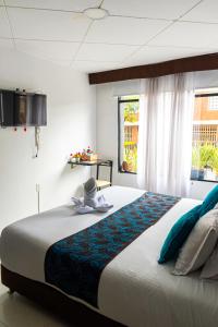 um quarto com uma cama grande e uma janela em Central House Hotel em Bogotá