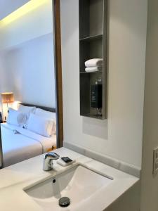 a bathroom with a sink, mirror, and bathtub at Hostal Spa Empúries in L'Escala