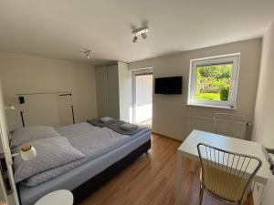 a bedroom with a bed and a table and a window at Dwa osobne pokoje z kuchnią i łazienką na wyłączność- niedaleko plaży in Gdynia
