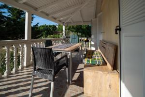 a porch with a wooden table and chairs at Apartments Domic in Banjole