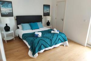 a bedroom with a large bed with blue pillows at Azorean Flats V Heart of Ponta Delgada - Centro in Ponta Delgada