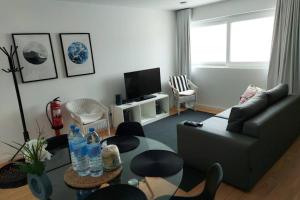 a living room with a couch and a table with water bottles at Azorean Flats V Heart of Ponta Delgada - Centro in Ponta Delgada