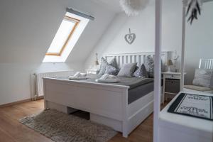 a white bed in a room with a window at Gästehaus Schlossblick in Wernigerode