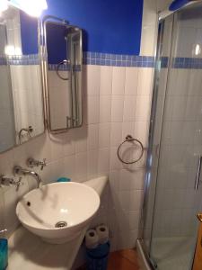 uma casa de banho com um lavatório e um chuveiro em Apartamento Aguas del Sella em Precendi