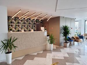 um lobby com vasos de plantas na parede em Hotel Clas Mamaia Nord em Mamaia Nord – Năvodari