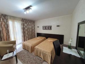 ein Hotelzimmer mit einem Bett und einem Stuhl in der Unterkunft Vila CLASS in Vatra Dornei
