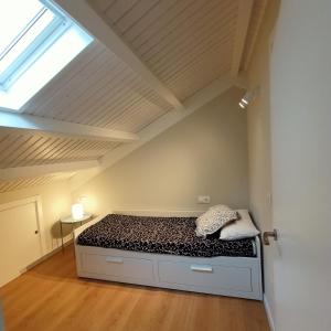 a bedroom with a bed in a room with a skylight at APARTAMENTO A CASIÑA in Cangas de Morrazo