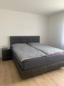 a large bed in a bedroom with a white wall at SD-Apartment in Spielberg