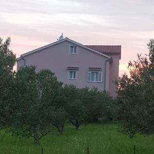 una casa en un campo con árboles delante en Apartments Maričić Rab Island, en Rab