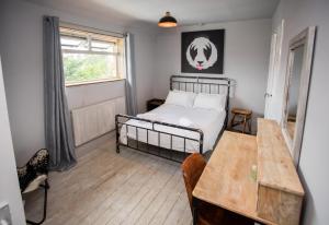a bedroom with a bed and a table and a window at James’ Place @ Bike Park Wales and The Brecon Beacons in Merthyr Tydfil