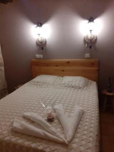 Saint-Sernin-du-Bois的住宿－Le grand bonheur，一张带白色床单的床和墙上的两盏灯