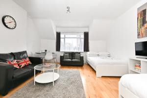 a living room with a black couch and a table at Soho Apartment, Theatres & Old Compton Street in London