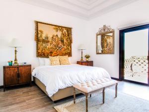 a bedroom with a large bed with a painting on the wall at Hotel Boutique Villa Toscana in Hermosillo