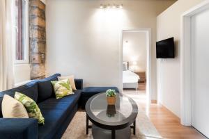 un soggiorno con divano blu e tavolo di Luxurious Art Apartments ad Atene