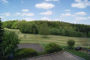 uma vista para um campo com uma cerca e árvores em Chaityfontaine em Pepinster