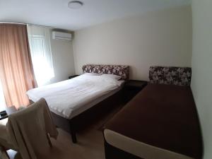 1 dormitorio con 1 cama, mesa y sillas en MiMOZA 2, en Jagodina