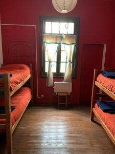 a room with three bunk beds and a window at Malecon en calle Techada Hostel in Capilla del Monte