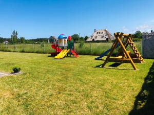 a group of playground equipment on a grass field at Domki VIP dla rodzin Ustka in Ustka