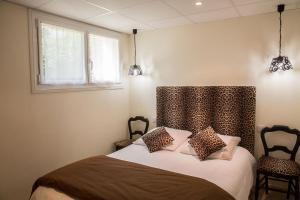 En eller flere senge i et værelse på Chambres Au Jardin Fleuri