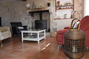 ein Wohnzimmer mit einem Sofa und einem Kamin in der Unterkunft Le Moulin de Charzay, éco-gîte familial en Deux-Sèvres, Nouvelle Aquitaine 