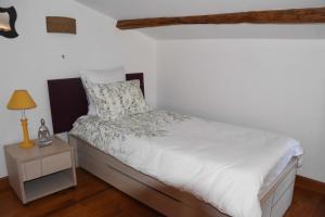 a bedroom with a bed with a night stand and a lamp at Le Moulin de Charzay, éco-gîte familial en Deux-Sèvres, Nouvelle Aquitaine 