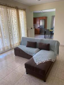 uma sala de estar com um sofá e uma cozinha em Treasures B&B em Paloúkia