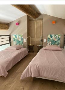a bedroom with two beds with pink comforter at Mas Galinette in Saint-Andiol