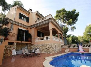 a villa with a swimming pool in front of a house at Ca Nostra · Mediterranean Villa in Majorca in Cas Català