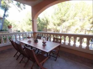 une terrasse couverte avec une table et des chaises en bois sur un balcon dans l'établissement Ca Nostra · Mediterranean Villa in Majorca, à Ca's Catala