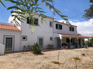 uma grande casa branca com um quintal em Casa Jardim Oasis em Lagoa