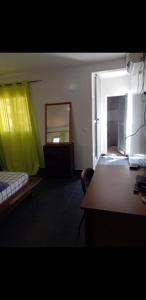Habitación con cama, espejo y escritorio. en Appartement Beau Séjour en Dakar